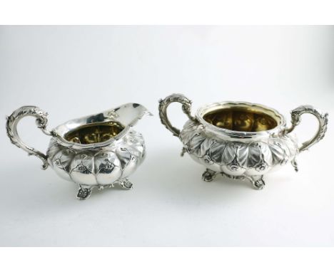 A GEORGE IV CREAM JUG AND A SUGAR BASIN of very similar design with lobed circular bodies, chased around the upper part with 