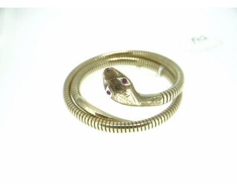 9CT YELLOW GOLD SNAKE FORM BANGLE with incised scale decoration to the coiled gas pipe body and with tapered smooth tail and 