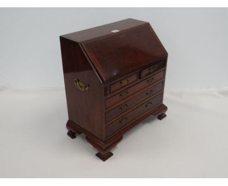 MAHOGANY MINIATURE BUREAU in the 18th Century-style on bracket feet and having three long and two short drawers, the slope hi