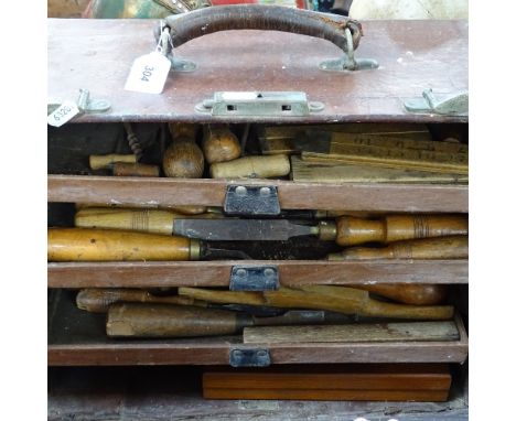 An Antique leather-covered carpenter's tool chest, with tools and rules 
