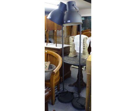 A contemporary standard lamp with large metal industrial style shade 