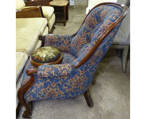 A Victorian upholstered armchair with mahogany show-wood, and a Victorian button footstool 
