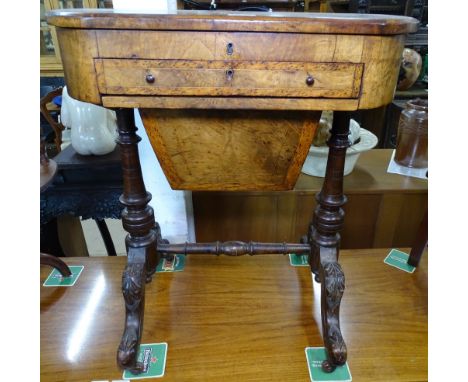 A Victorian walnut sewing / writing table, the cross-banded lid rising to reveal a fitted interior with fitted frieze drawer 