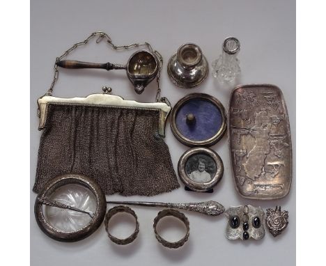 A box containing silver photo frames, a silver candlestick, napkin rings etc 