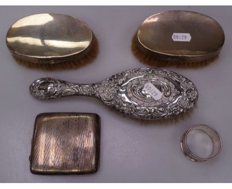 An engraved silver cigarette case, a silver napkin ring, 3 silver-backed dressing table brushes 