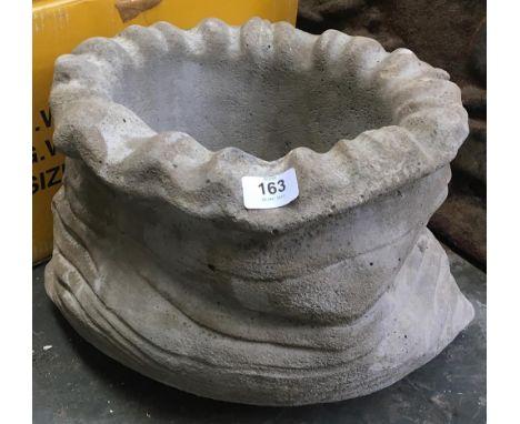 A composite stone sack shaped planter 