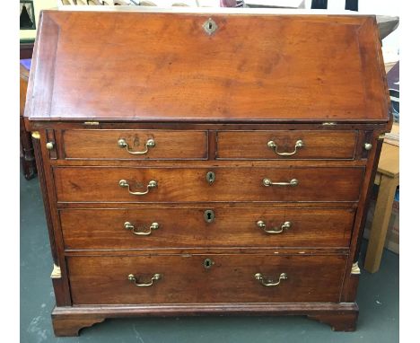A Georgian mahogany bureau, the fall front revealing a fitted interior of pigeon holes, above two short and three graduated d