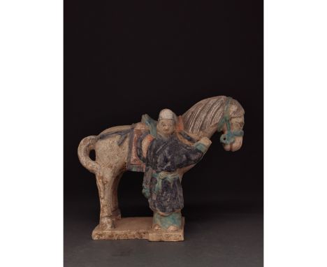 Ca. 1368-1644 AD. Chinese Ming Dynasty. Ceramic horse and groom figurine. This figurine shows a groom, dressed in a dark blue