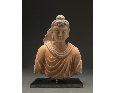 300-500 AD. Gandharan. Painted stucco figure of Buddha dressed in a flowing yellow Kasaya (monastic robe). The head features 