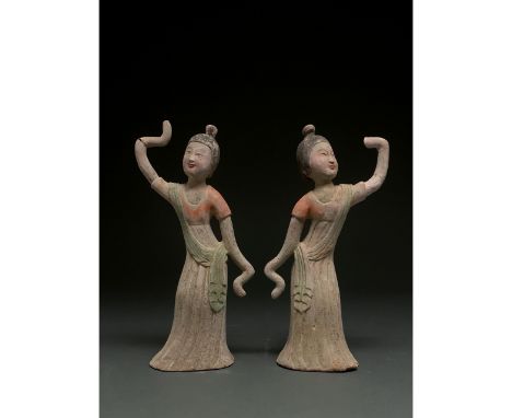 C. AD 618 and 907. Tang Dynasty. A pair of delicate Tang Dynasty dancers with long sleeves. Both dancers are wearing a long f