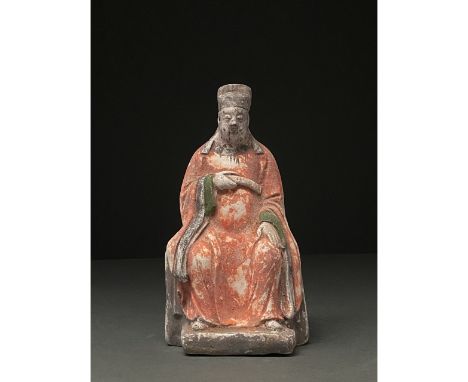 Ca. 1368-1644 AD. Chinese Ming Dynasty. A ceramic Lohan figure depicted seated wearing bright red robes with green and black 
