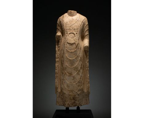 549 - 577 AD. Northern Qi Dynasty. Cream-coloured stone torso of a standing Buddha, without hands or head which would probabl