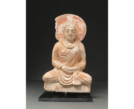 300-500 AD. Gandharan. Painted stucco figure of a Buddha backed by a circular halo. He wears an elaborately draped robe, pick