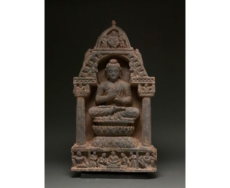 100 – 300 AD. Gandharan. This majestic schist temple panel depicts a seated Buddha within a temple setting. Buddha, who wears