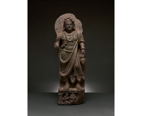 100-300 AD. Gandharan. Schist figure of a bodhisattva, backed by a halo, who stands, gazing serenely into the distance. He is