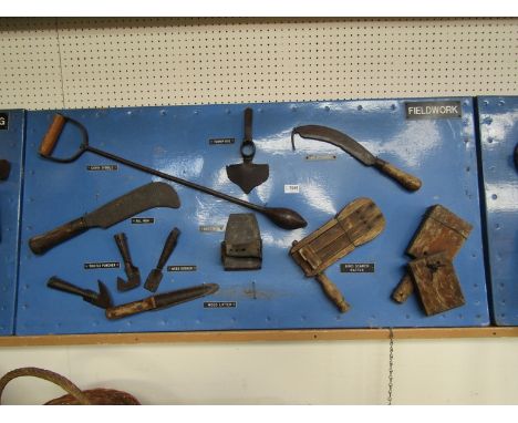 A bygone display board showing tools for fieldwork including weed lifter, turnip hoe etc 