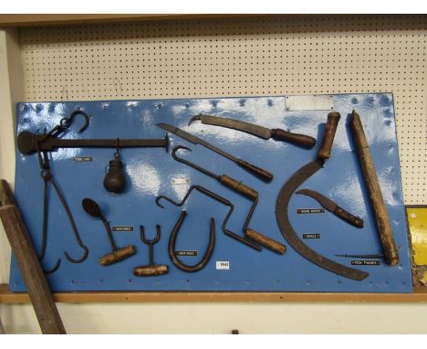 A bygone display board showing tools for harvest including wimble