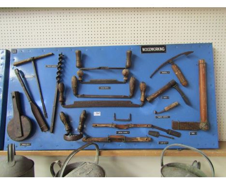 A bygone display board showing tools for woodworking including draw knives, timber scrives etc 