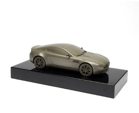 ANTHONY HOLT SILVERSMITHS A COLD CAST OF AN ASTON MARTIN DB9, mounted on a black plinth, measuring approx. 9in. x 4in. x 3in.