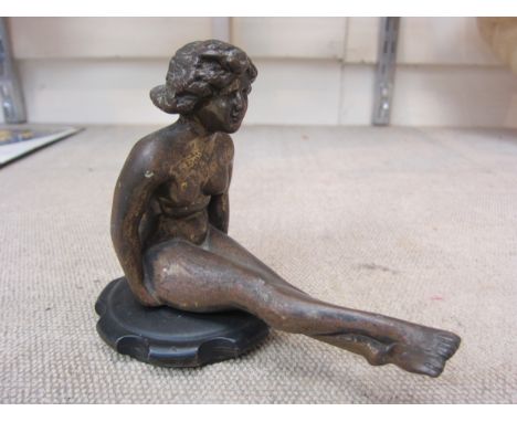 A bronze car radiator mascot circa 1900-1930, in the form of a seated naked lady 