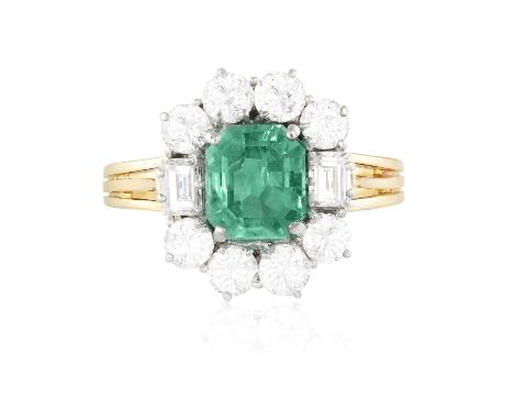 AN EMERALD AND DIAMOND CLUSTER RINGThe rectangular cut-cornered emerald within a four-claw setting to a brilliant-cut diamond