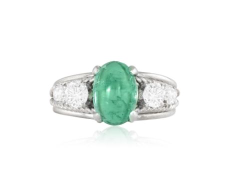 AN EMERALD AND DIAMOND RINGSet with an oval emerald cabochon with graduated brilliant-cut diamonds to either side, between bi