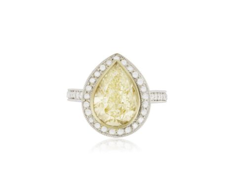 A DIAMOND DRESS RINGThe pear-shaped diamond of yellow tint in a rubover setting, within a surround of brilliant-cut diamonds 