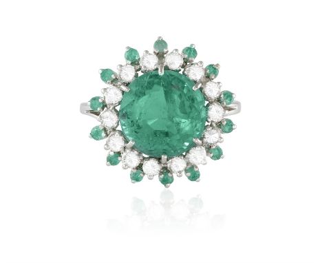 AN EMERALD AND DIAMOND CLUSTER RINGThe central circular-cut emerald weighing 5.89cts within a brilliant-cut diamond frame and