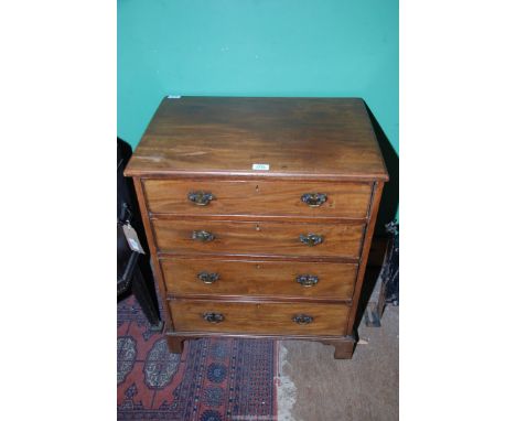 A compact Bachelor's Chest of four long Drawers having shaped backplate brass drop handles and standing on bracket feet, 24 5