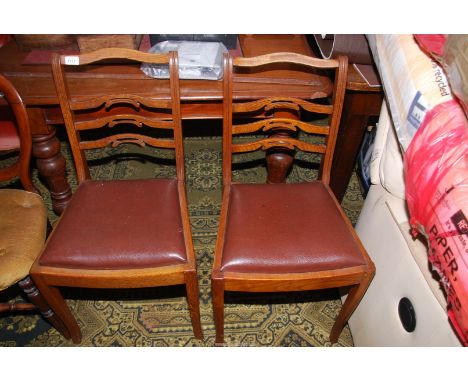 A pair of Oak framed pierced detail ladder back side Chairs with brown upholstered drop-in seats.