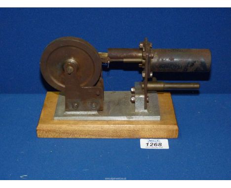 A steel, aluminium and brass hot air (Stirling cycle) Engine mounted on a hardwood base, and having a 3 1/2" diameter flywhee