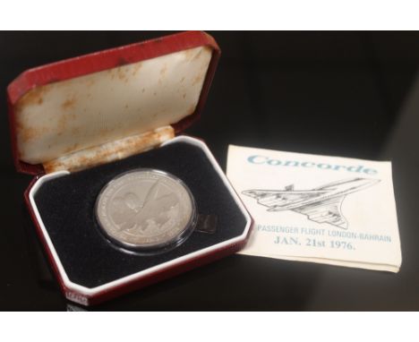 A CASED PLATINUM COMMEMORATIVE 1976 COIN by Pobjoy Mint Ltd. commemorating Concorde's first passenger flight from London to B