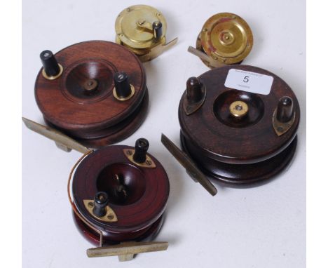 A collection of antique and vintage fishing reels to include a Wooden Starback, and also all brass centre pin reels, one mark