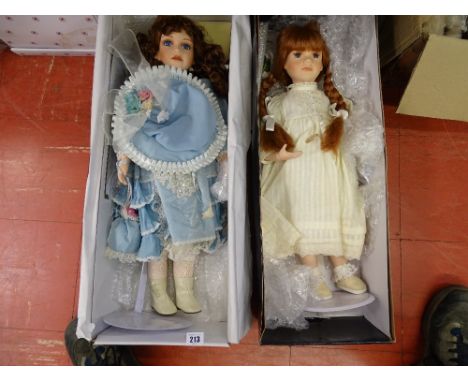 Doll with cream silk dress and bead necklace, on stand (boxed) and a doll with blue silk dress with pearl necklace and bonnet