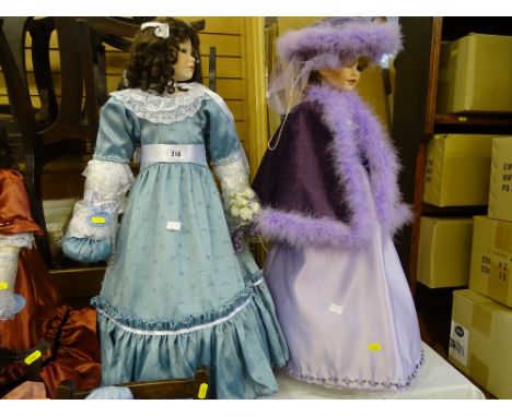 Two tall dolls, one in light blue long dress with bouquet of roses and curls and the other with purple silk dress with fur li