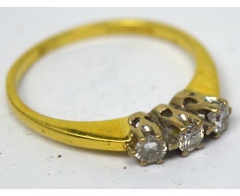 An 18ct yellow gold ring set with a row of three small diamonds, size K, approx 2g.