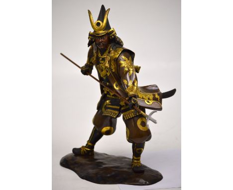 A good Japanese Meiji period bronze and gilt-heightened figure of a warrior holding a spear and with tantō beneath his coat, 