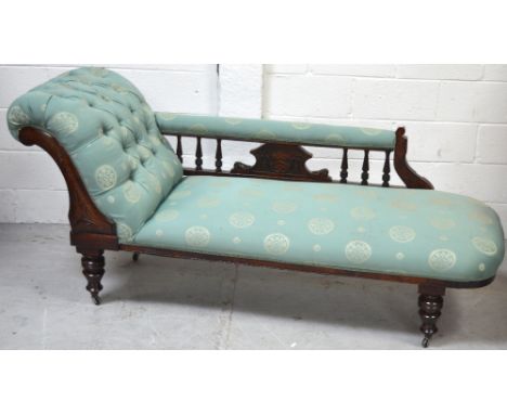 A Victorian mahogany chaise longue, the carved central panel with turned supports to either side on squat baluster legs and c