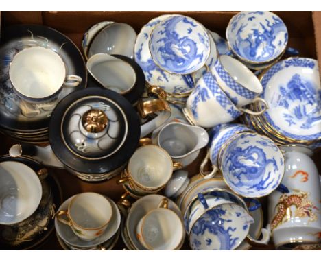 A Japanese mid-20th century tea service, black ground decorated in relief with dragon chasing a pearl; cups, saucers, plates,