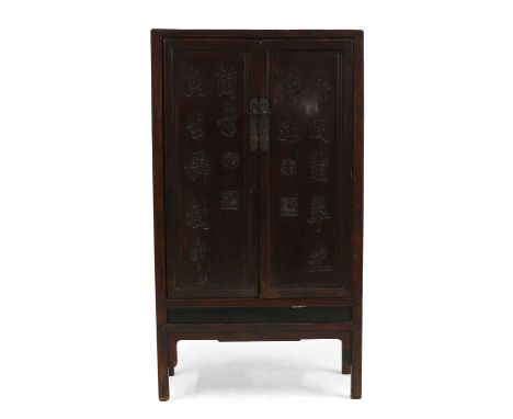 A lacquered and carved cabinet,  19th century, Chinese, the doors carved with seals and characters enclosing a shelf and draw