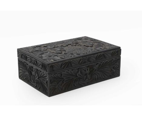 An Indian ebony work box  19th century, the exterior carved all over with stylised foliage and scrolls, the interior with a l
