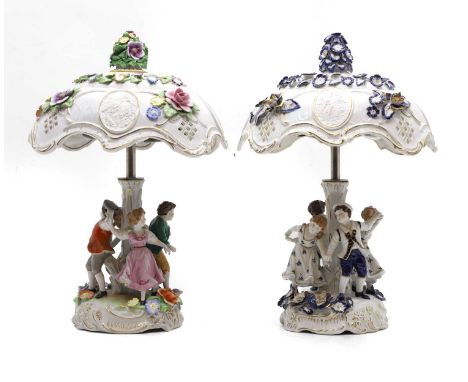 A Schierholz porcelain lamp the shade with flowerhead decoration on a column encircled by four dancing figures,41cm high and 