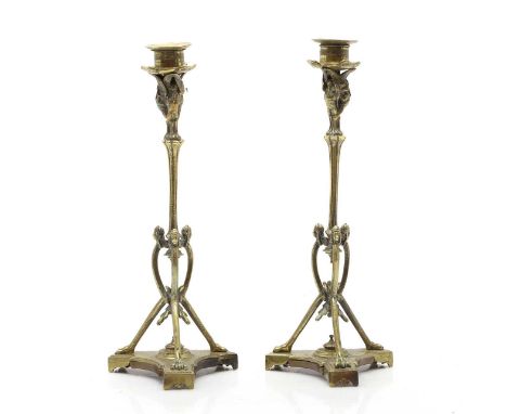A pair of Victorian cast candlesticks, late 19th century, modelled with storks holding the sconces, on a tripod base, with ma