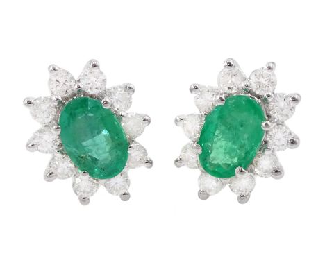 Pair of 18ct white gold oval cut emerald and round brilliant cut diamond cluster stud earrings, stamped, total emerald weight