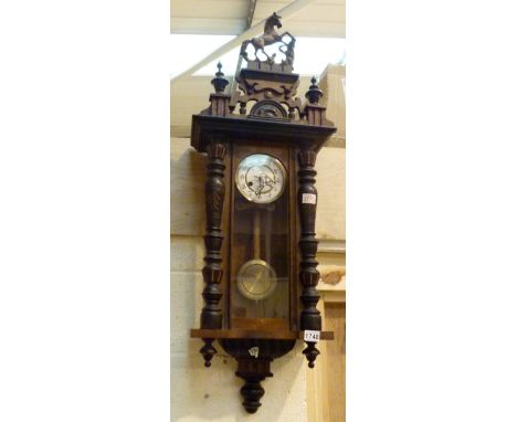 Walnut cased Vienna chiming wall clock with carved columns and topped with a horse 