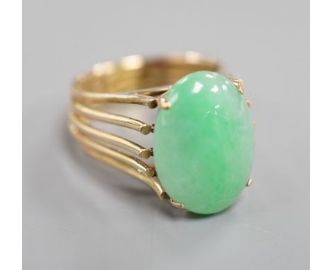 A yellow metal and cabochon jade set oval dress ring, size P/Q, gross weight 8.4 grams.