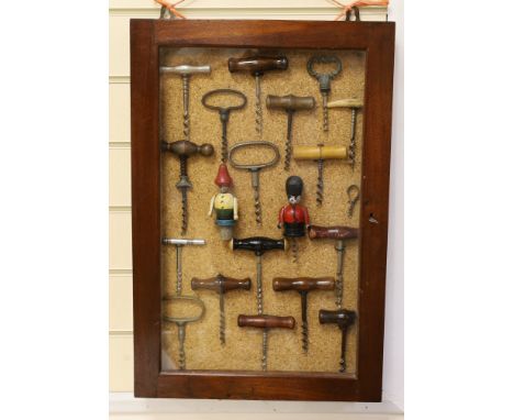 A collection of vintage corkscrews, some novelty, in glazed mahogany vase with key