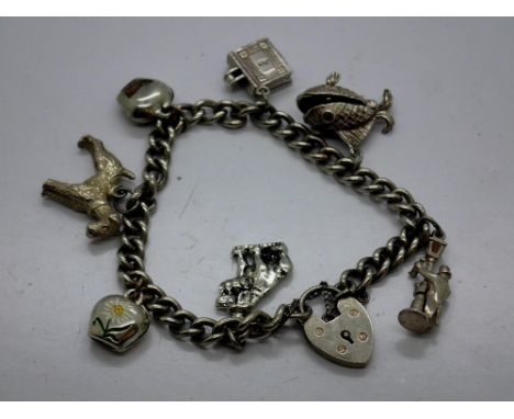 Hallmarked silver charm bracelet with seven charms, padlock clasp and safety chain, L: 18 cm. UK P&amp;P Group 0 (£6+VAT for 