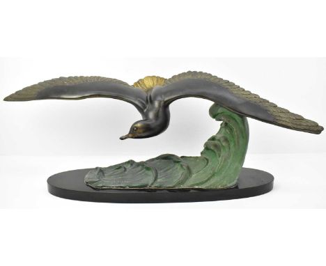 † M LEDUCQ (20th century); a large patinated bronze figure a seagull hovering over crashing waves, raised on elongated oval m