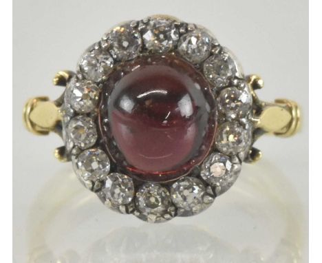 A Victorian 18ct yellow gold cluster ring, the central cabochon garnet approx 5ct, surrounded by fourteen brilliant cut diamo